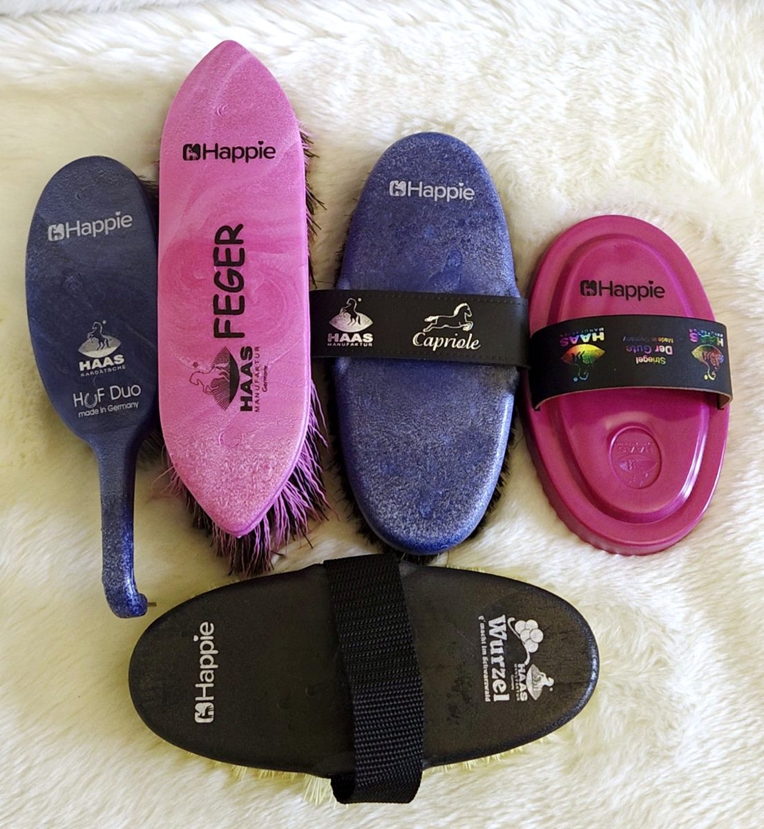 Das Haas x Happie Bürsten-Set: Huf-Duo, Feger, Striegel, Capriole und Wurzelbürste mit Happie-Logo